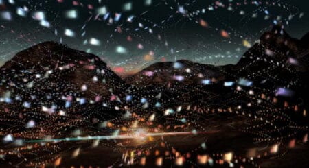 A mountainous landscape with small illuminated,multi-coloured shapes super imposed over the top of the image.