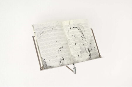 A piece of sheet music with the notes falling off the pages.