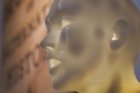 White model of a persons head which is illuminated from the inside.