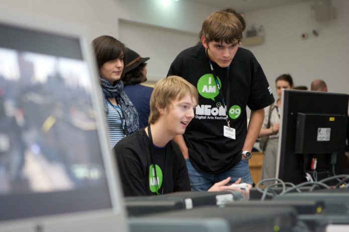 Three people looking at a computer screen.