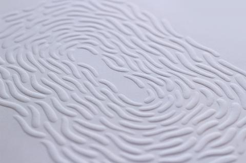 Wormlike shapes embossed on white paper.