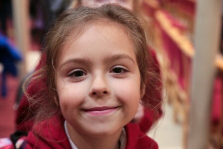 A child in school uniform smiling at the camera.