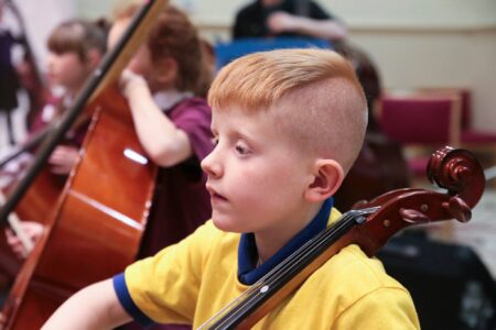 A school child playing a cello