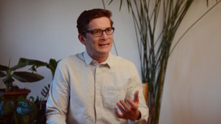 A person wearing a white shirt and glasses.