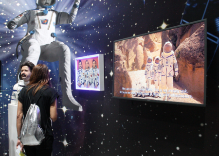 Person standing in front of a wall looking at images of astronauts.