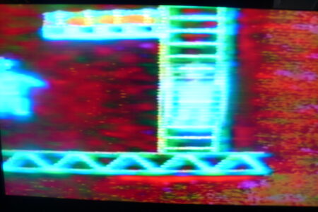 A screen grab of what looks like the computer game Donkey Kong. The image is of computer generated ladders which are connected to steel girders. They are teal in colour and are situated on a dark red background.