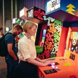 Marie Foulston, curator, playing an arcade video game.