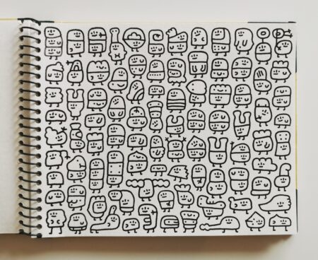 Small character illustrations on white sketchbook page drawn by Akinori Oishi