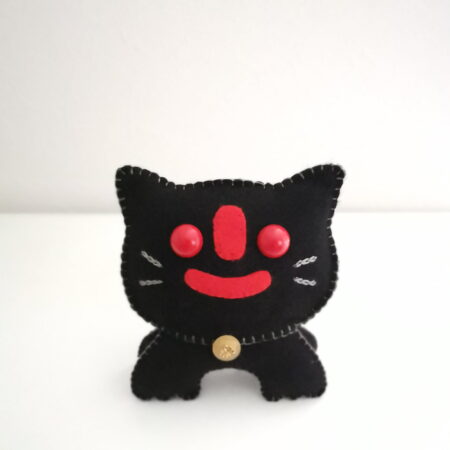 Homemade black cat plush toy with red face.