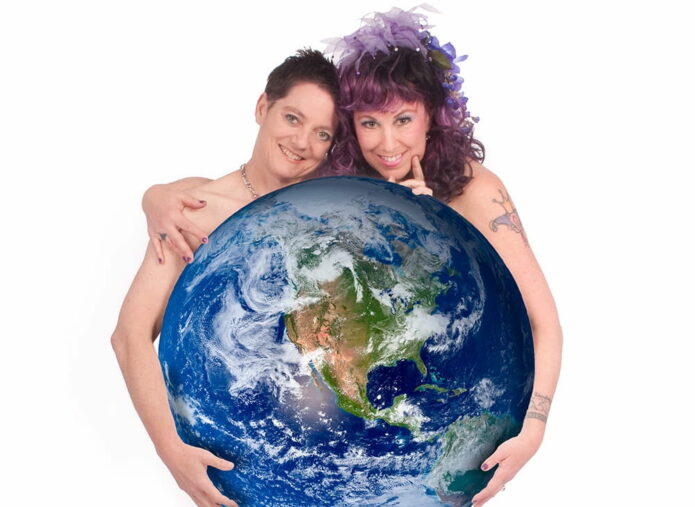 Artists Beth Stephens and Annie Sprinkle holding the planet earth.